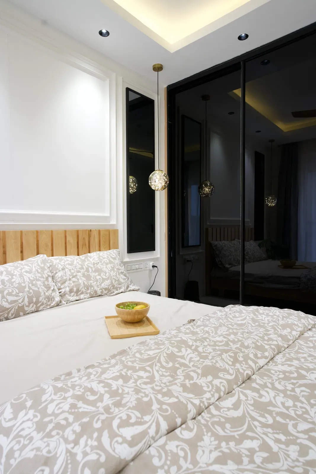 Bedroom with black glass wardrobe and oak headboard — The Aakar